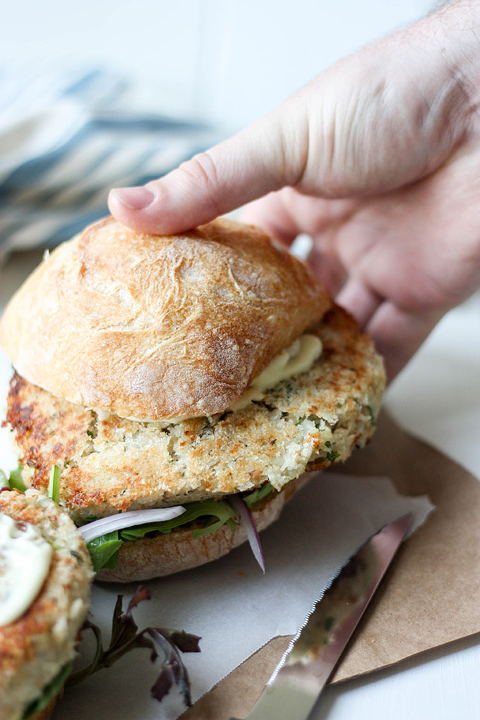 hand reaching out to grab salmon burger