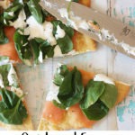 overhead of smoked salmon pizza on white and blue board with knife, pinterest graphic - text on bottom of image