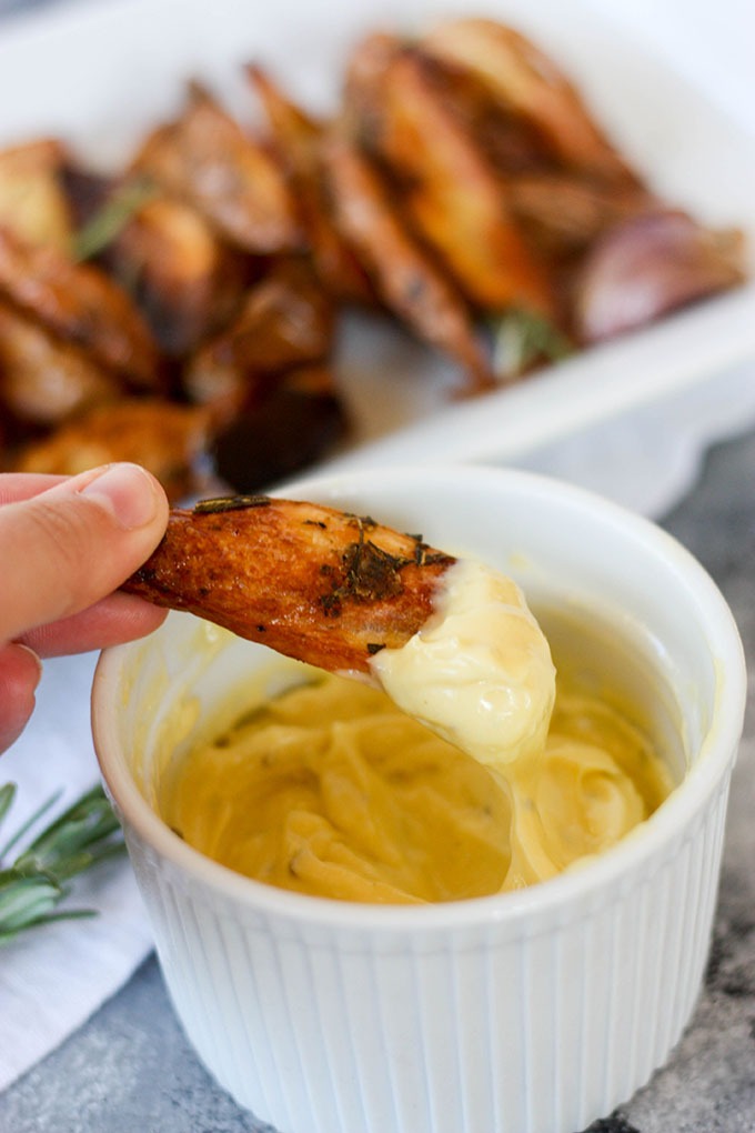 hand holding chip dipped in aioli