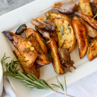 oven baked fries on white plate with rosemary sprig