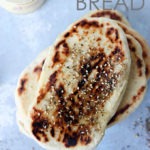 za'atar naan bread on blue board with text on top section for pinterest