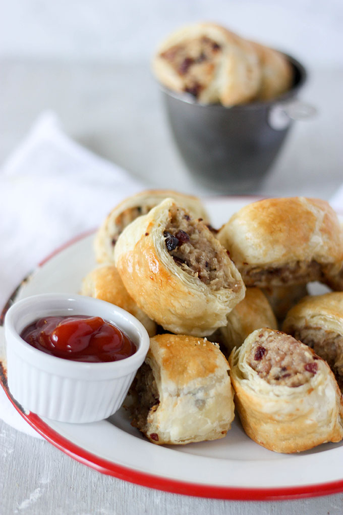 pork and cranberry sausage rolls on red and white enamel plate