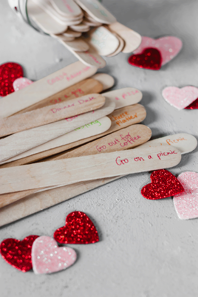 popsicle sticks laid out on grey board, date night ideas written on them
