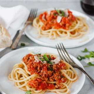 close up of amatriciana on white plate with antique fork