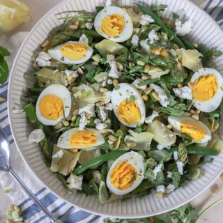 overhead view of artichoke salad with rustic spoon on left hand side of bowl