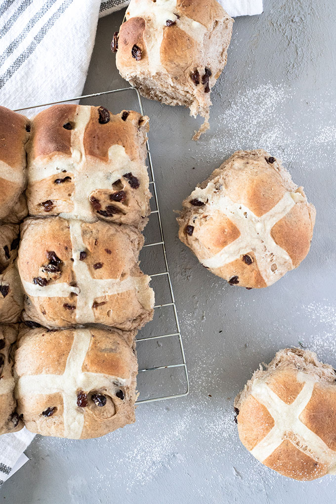 hot cross buns on a wire rack, placed on a grey board