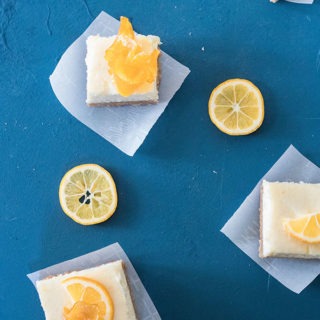 three slices of the lemon cheesecake bars on parchment paper