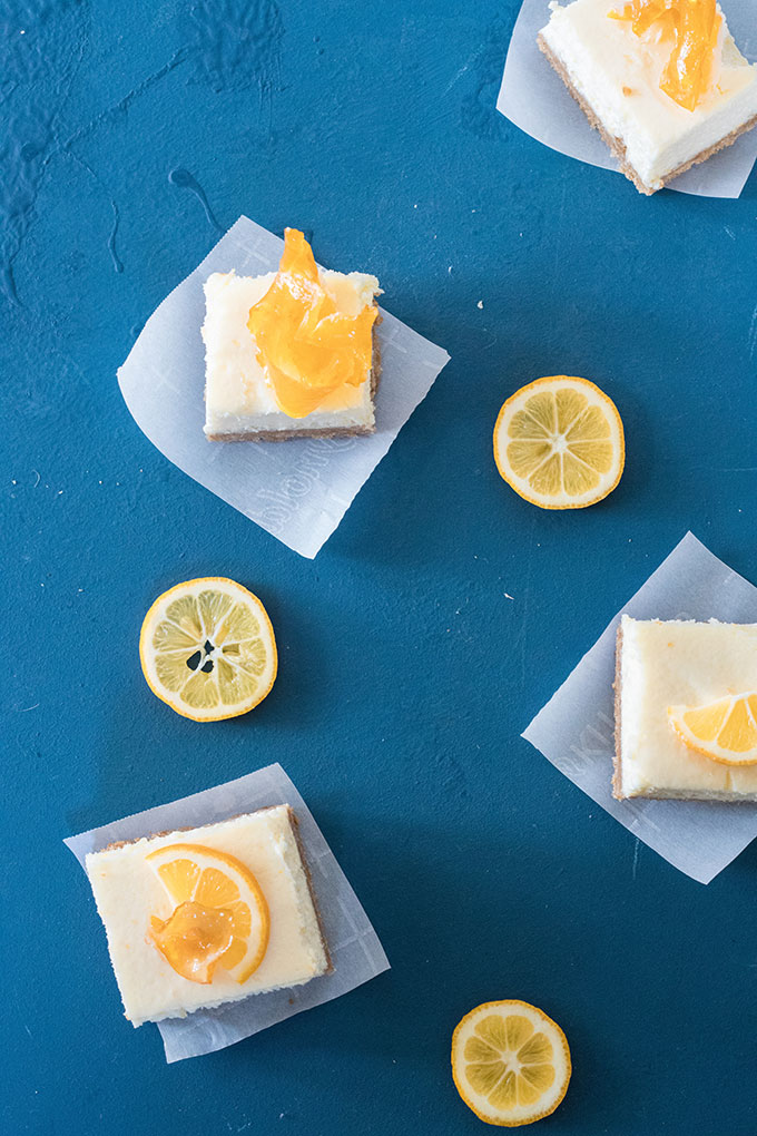 three slices of the lemon cheesecake bars on parchment paper