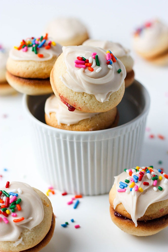 pile of vanilla sandwich cookies in white ramekin on white surface