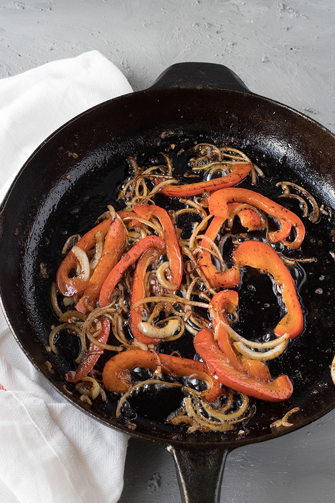 lightly charred onion and red pepper in cast iron skillet