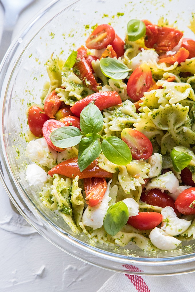 caprese salad in clear bowl on red and white linen