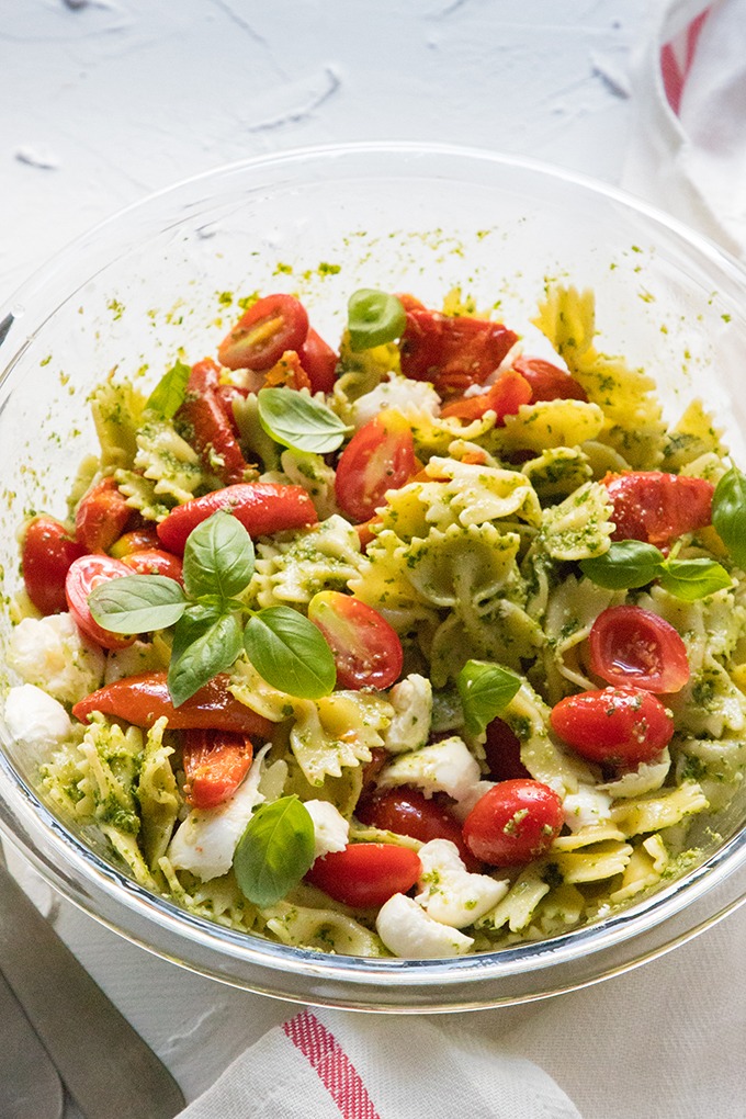 pesto caprese pasta salad in large glass salad bowl