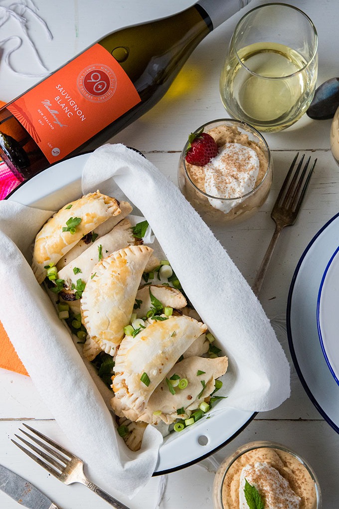 shrimp empanadas and white wine on a white table