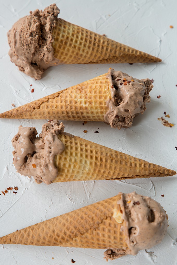 four ice cream cones laying flat on white board with chili chocolate ice cream in them