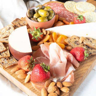 meat and cheese board featured with glass of red wine