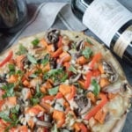 veggie pizza on wooden board with bottle of wine