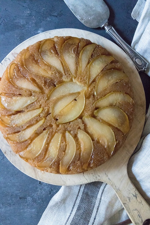 pear upside-down cake on a round wooden board
