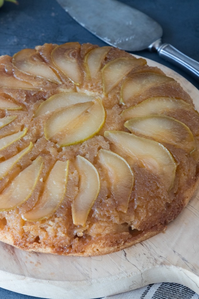 close up pear upside-down cake on wooden board