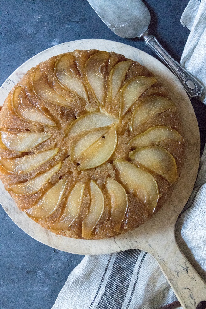 pear upside-down cake on antique round wooden board