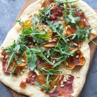 uncut butternut squash pizza on wooden board