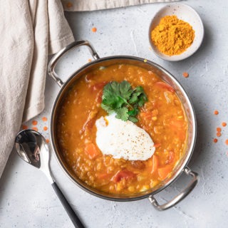lentil dal in metal dish with spoon and turmeric