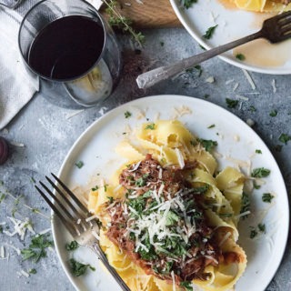 slow cooker beef ragu with pappardelle on white plate with antique spoon