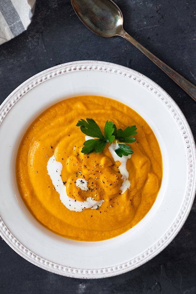 close up of carrot and ginger soup in white bowl