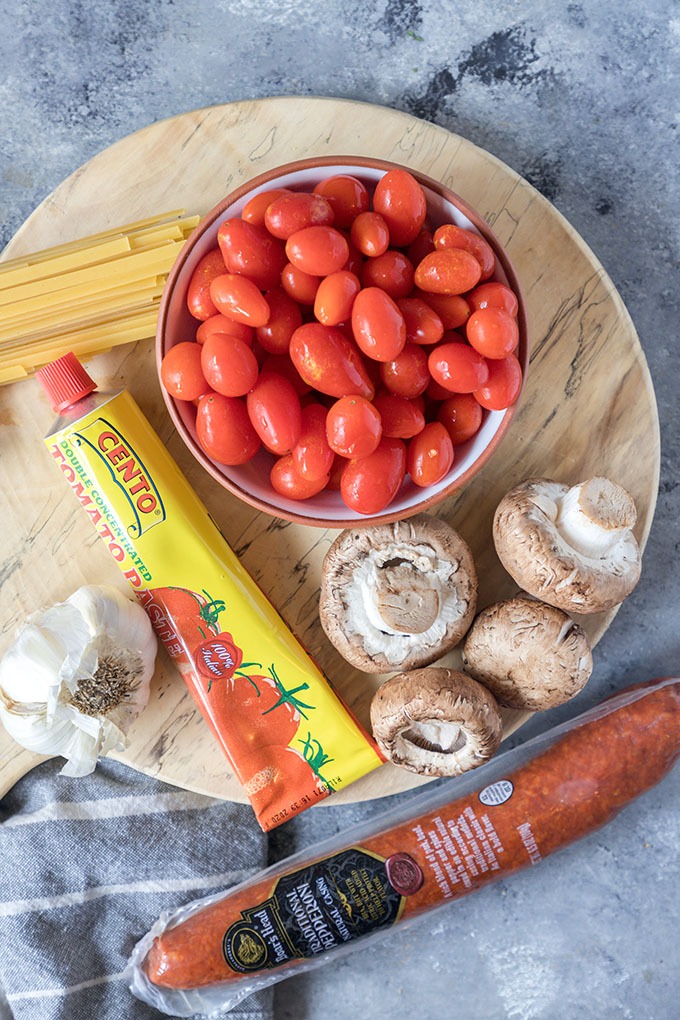 tomato chorizo pasta ingredients on wooden board