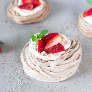 chocolate meringues with strawberries on grey board