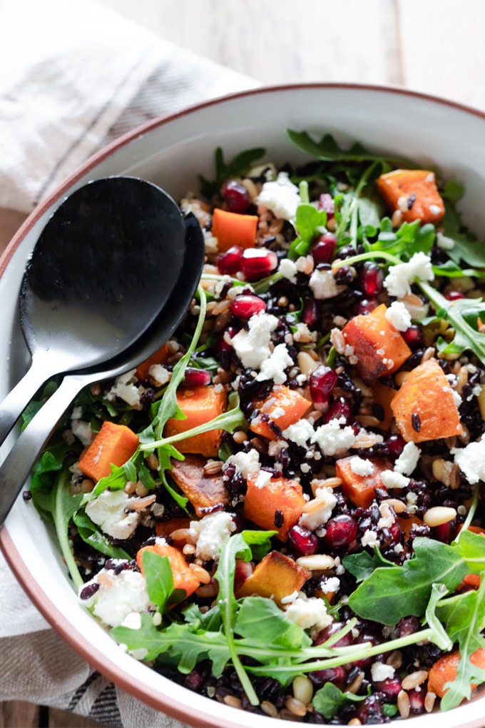 grain salad with black servers in white and brown bowl