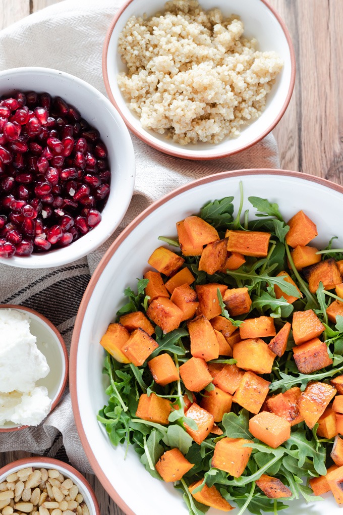 pumpkina and arugula in bowl with ingredients around side of bowl