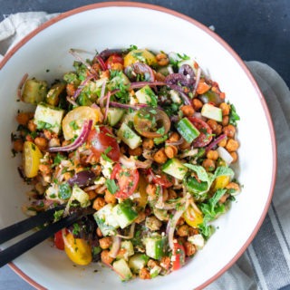moroccan chickpea salad in white bowl on linen