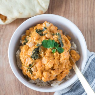 sweet potato chickpea curry in white bowl with gold fork