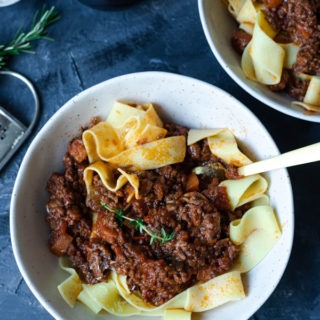 lamb ragu in bowls with fork