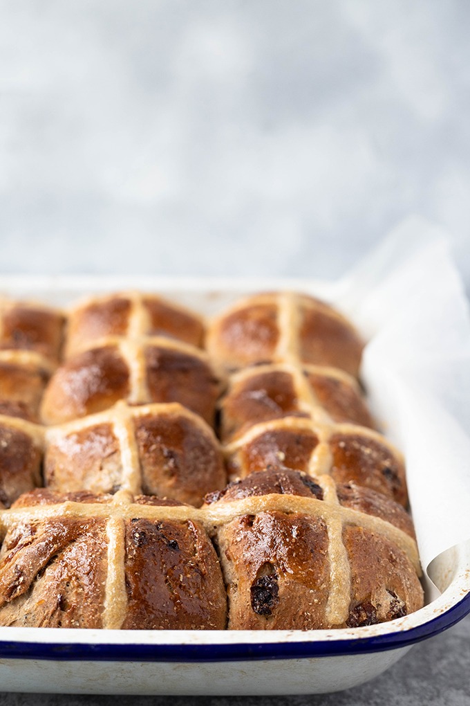 close up hot cross buns in baking pan 