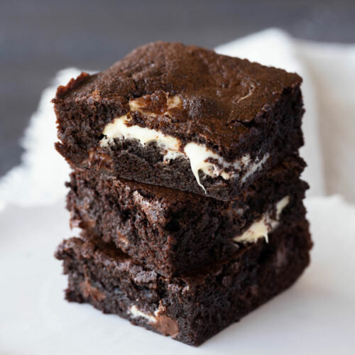 chocolate chip brownies stacked on a small white plate