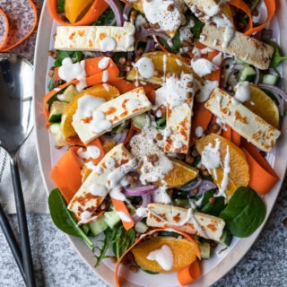 lentil halloumi salad close up on white salad platter