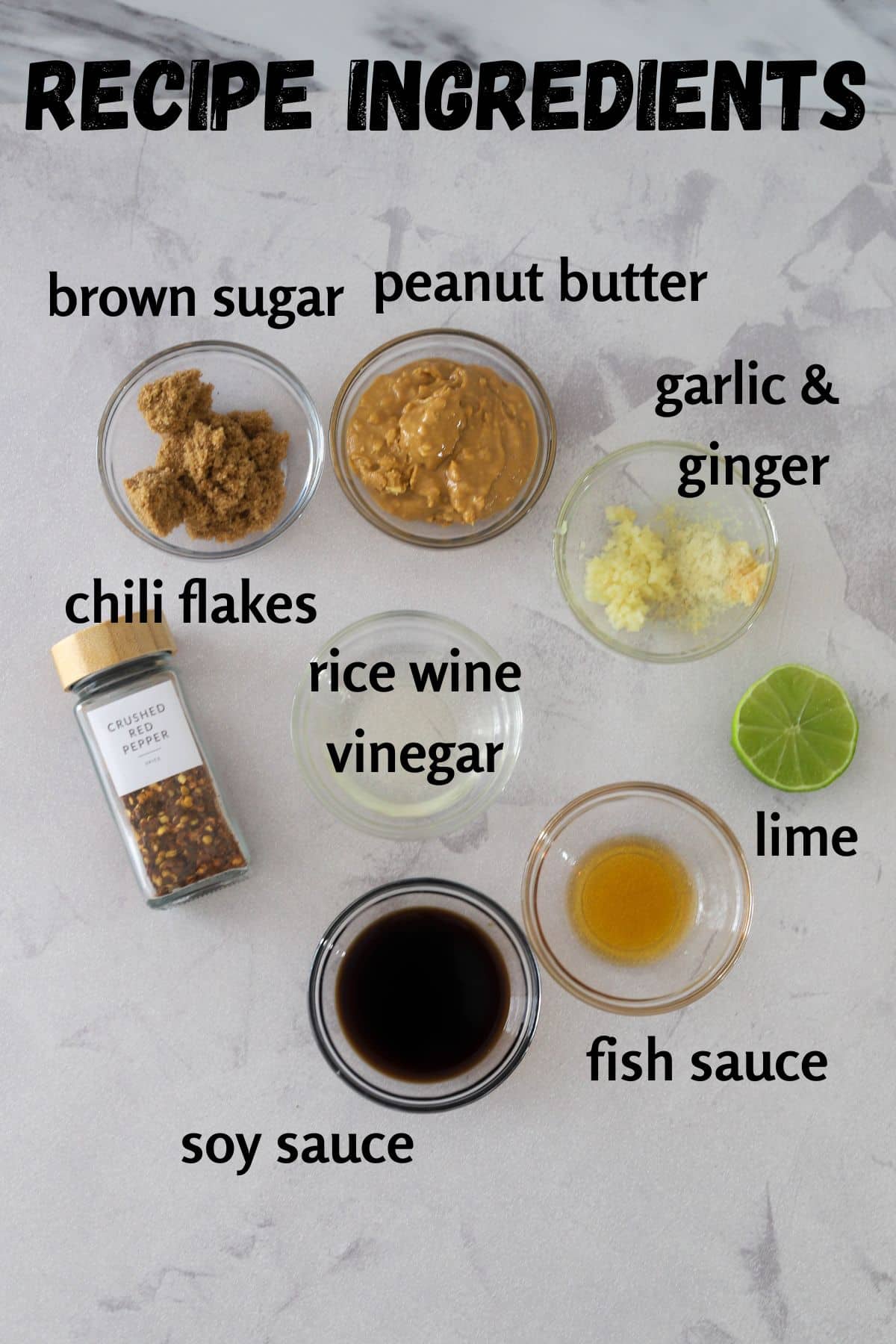 dressing ingredients laid out from top to bottom, left to right: brown sugar, peanut butter, ginger and garlic, chilli flakes, rice wine vinegar, lime, soy sauce, fish sauce.