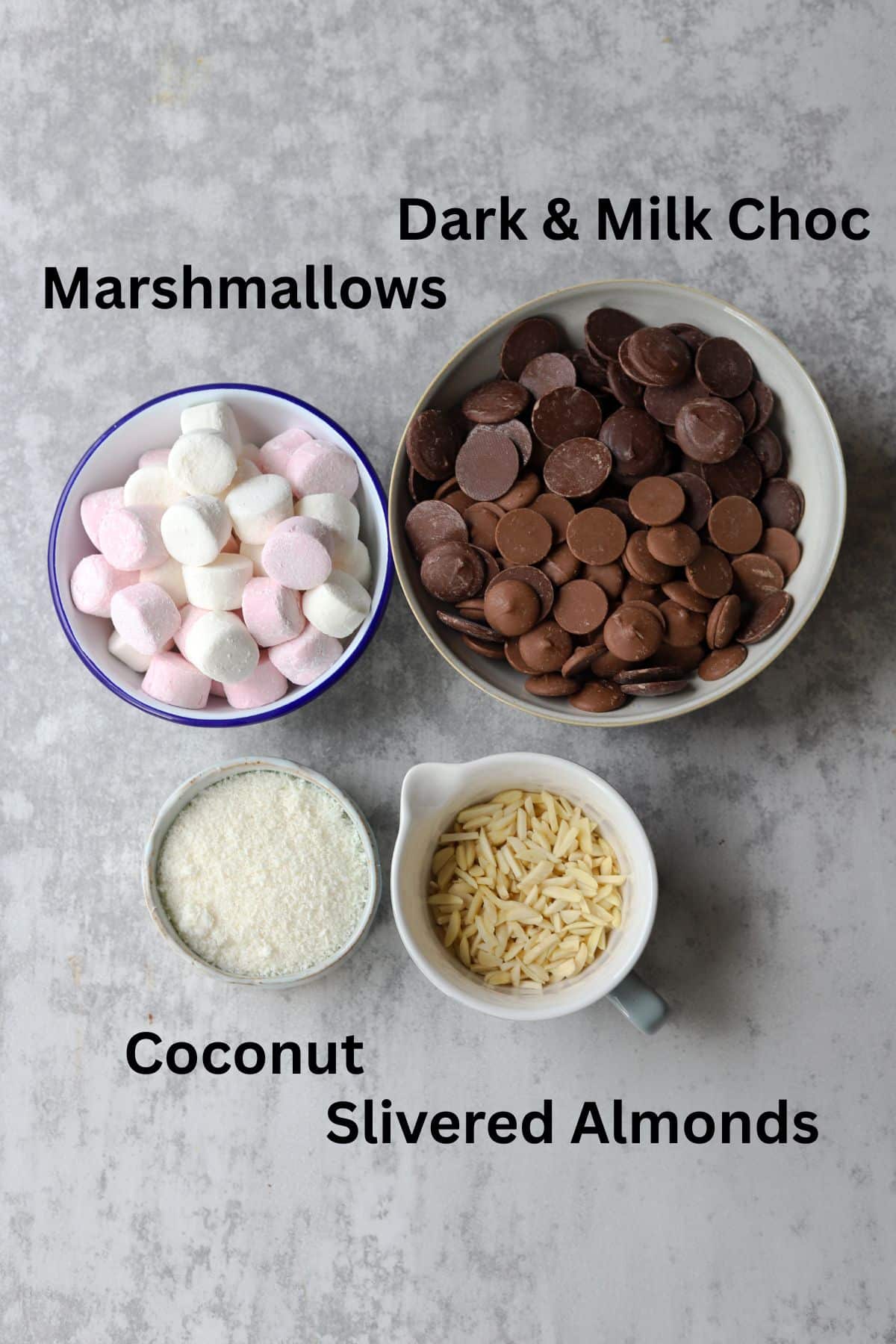 rocky road ingredients in small bowls on grey backdrop