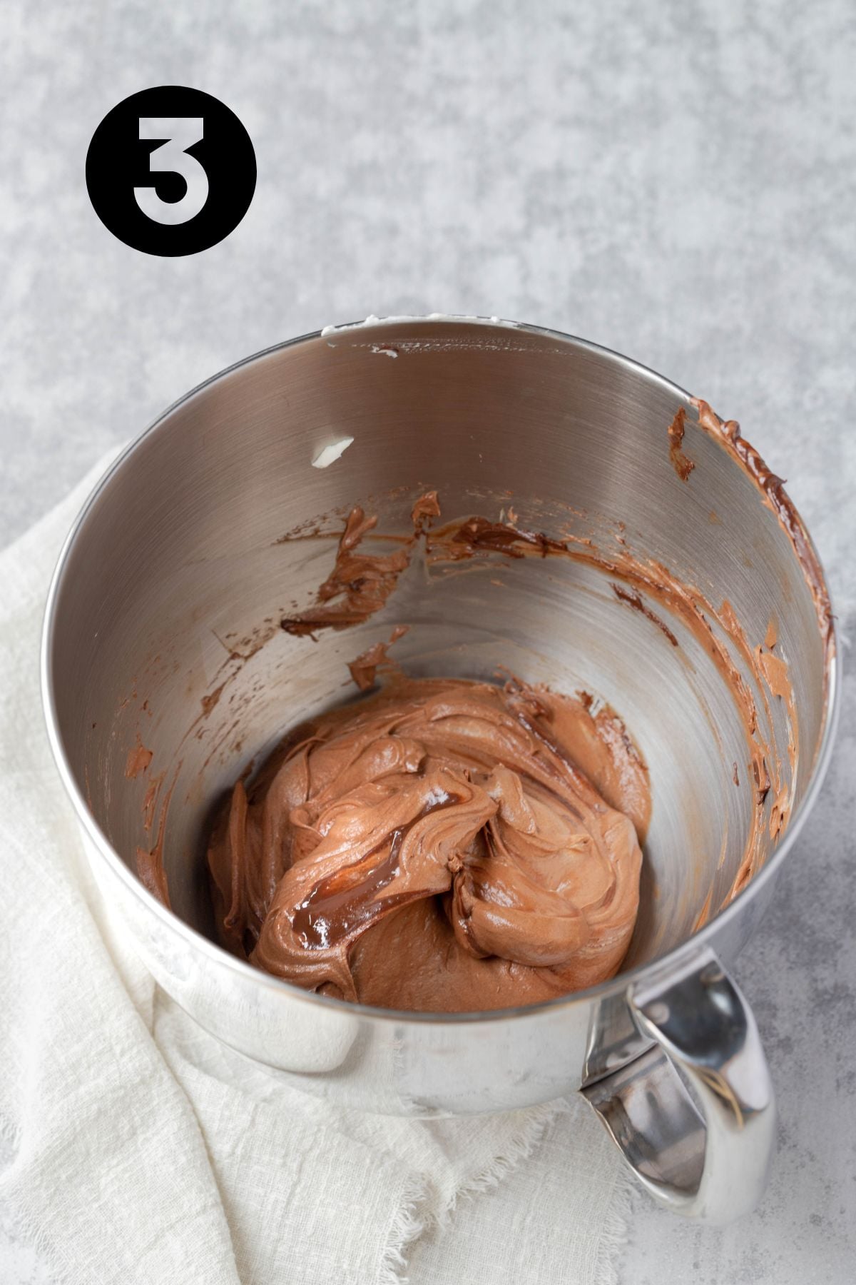 chocolate and whipped cream mixed together in stainless steel kitchen aid bowl on linen napkin.