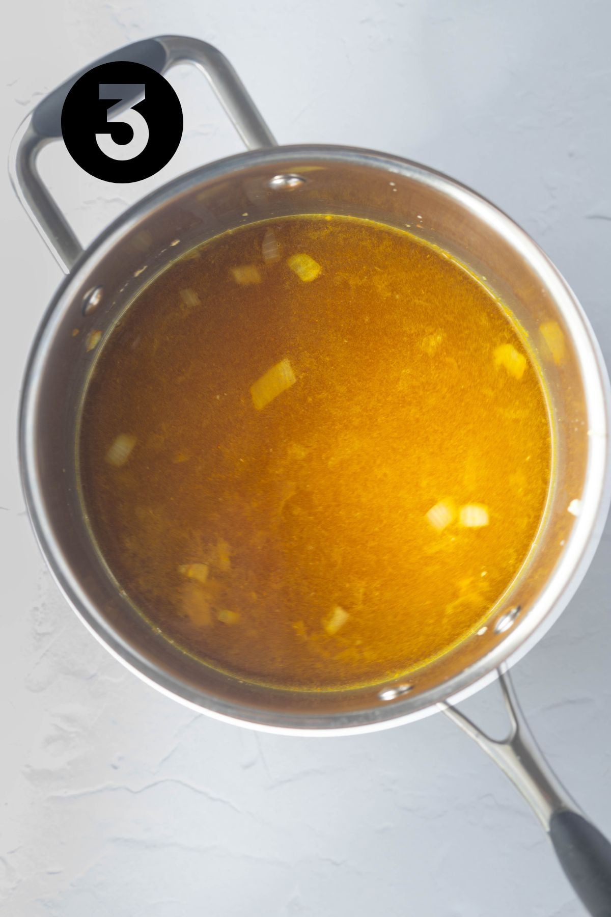 Stock added to dal mixture in the saucepan.