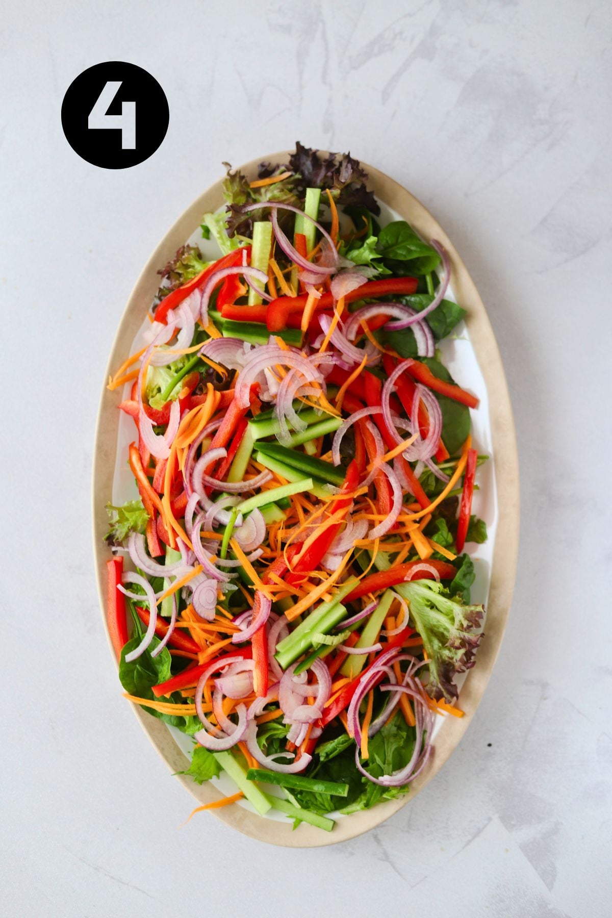 vegetables added in layers to the lettuce on the large platter.